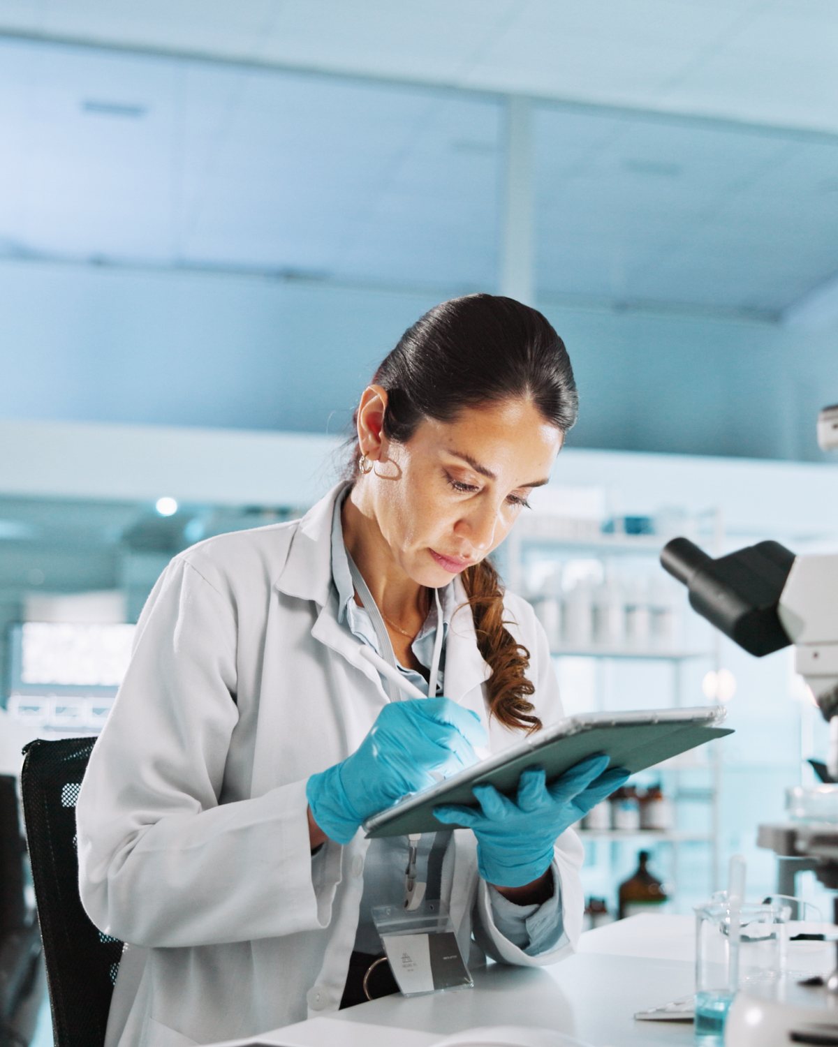 Une chercheuse prend des notes sur une tablette au laboratoire